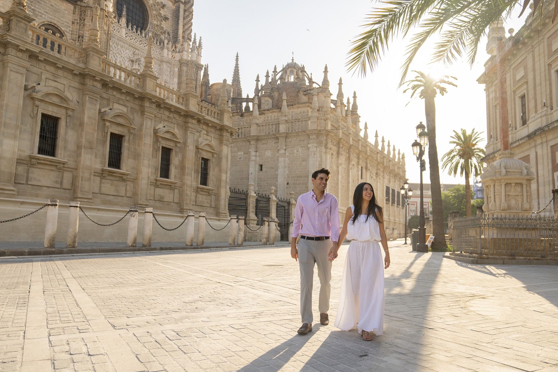 Couple walking hand in hand by Seville Cathedral