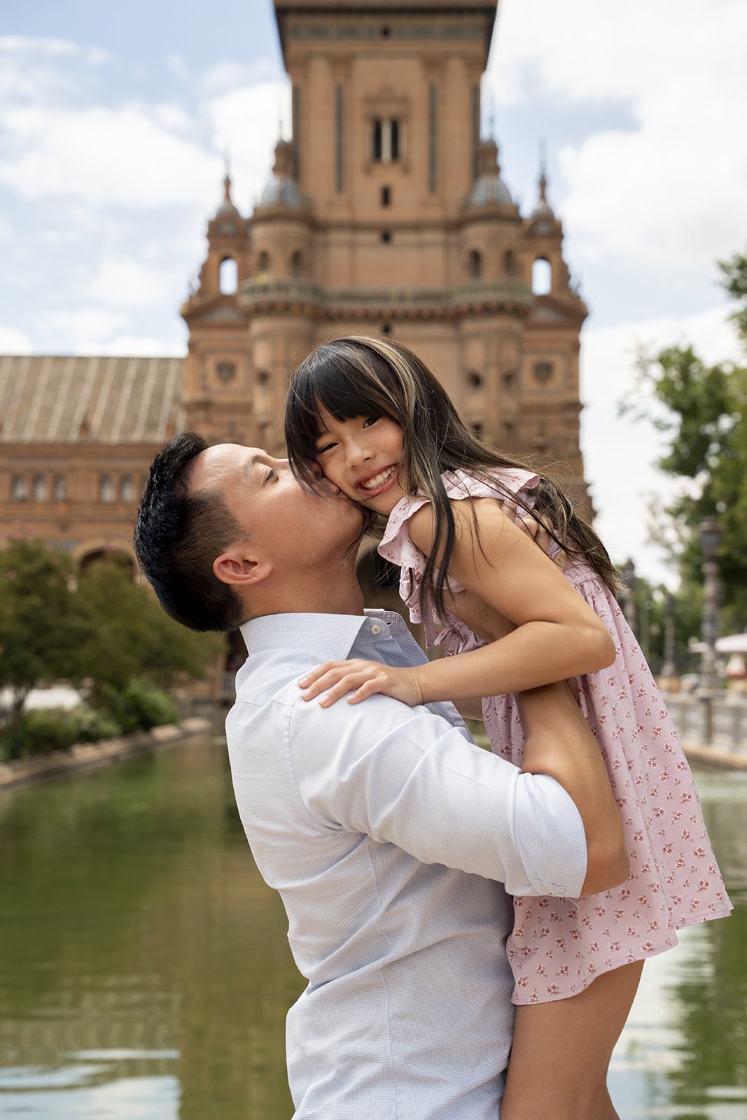 Father embracing daughter during a family photoshoot in Seville