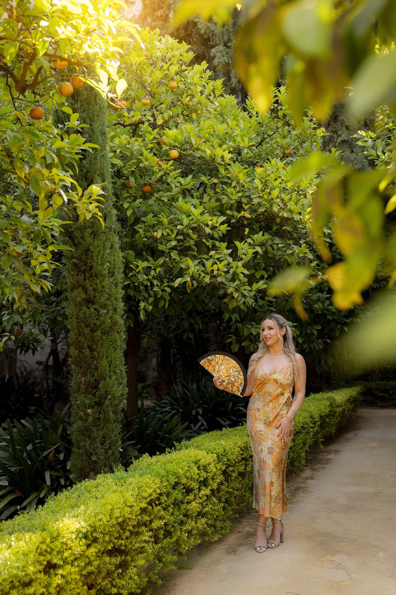 Vacation photoshoot among the orange trees of a Seville garden