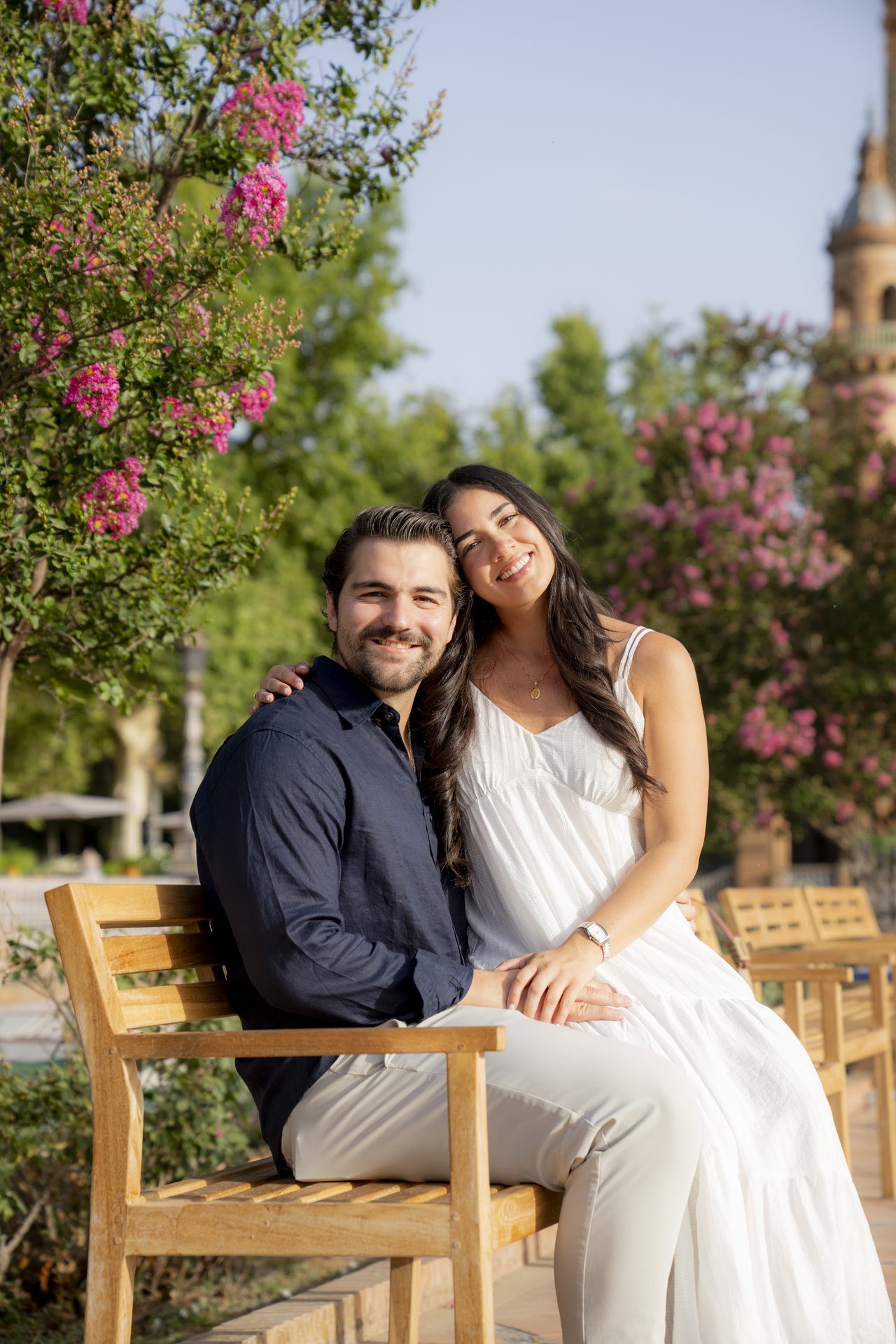 Couple seated beneath blossom trees at Plaza de España, Seville
