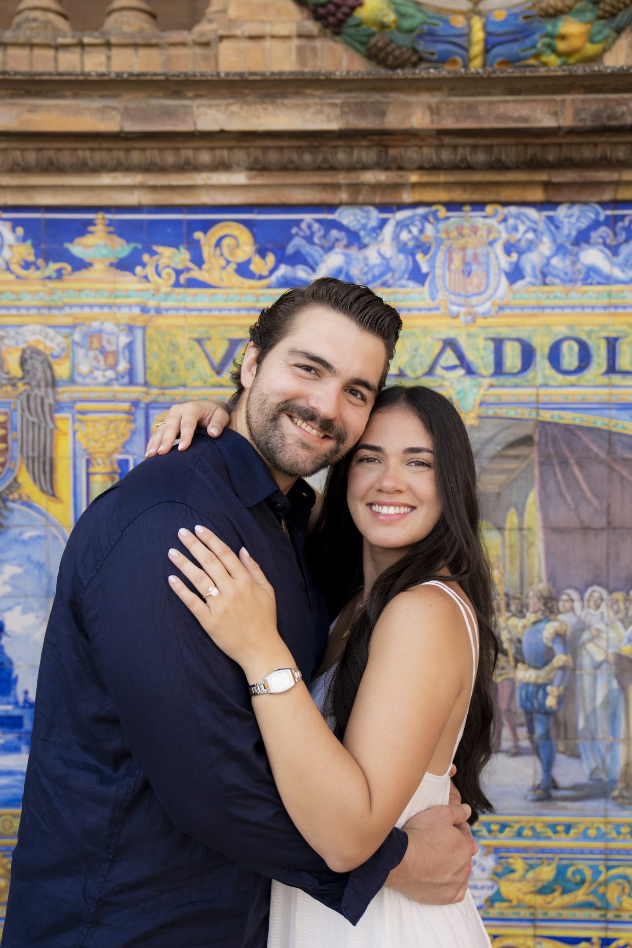 Engaged couple by the painted azulejo tiles at Plaza de España, Seville